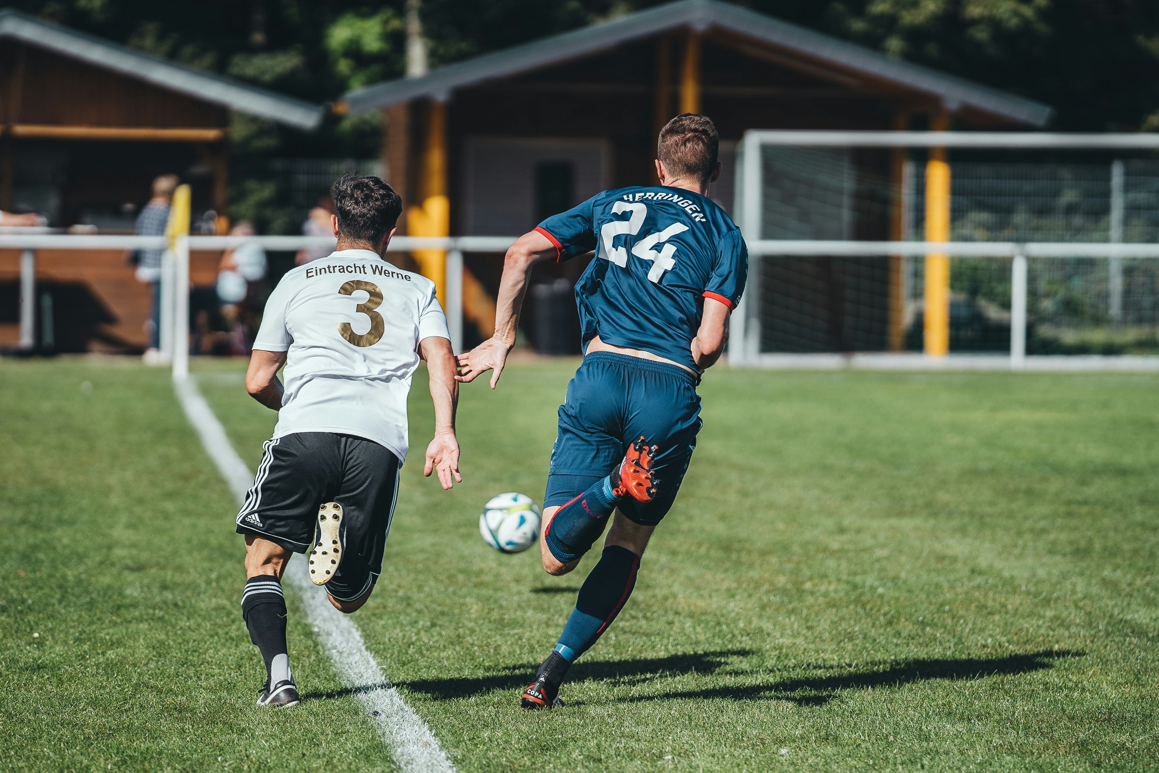 A footballer working through a high-intensity running interval on a training pitch, pushing hard before a recovery jog — the interval format at the centre of the aerobic base versus HIIT debate in football conditioning.