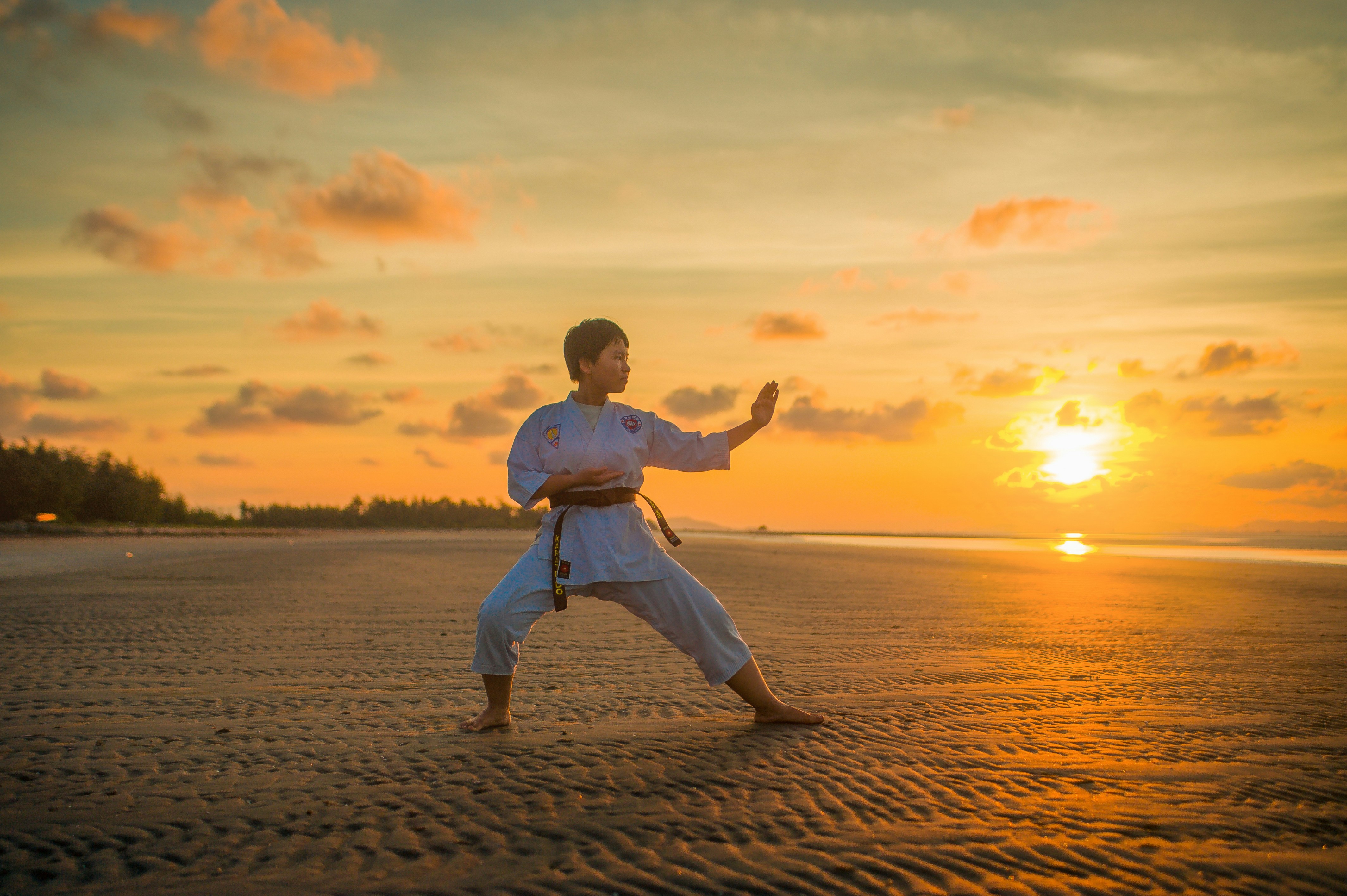A combat sports athlete performing a dynamic hip and shoulder mobility drill before training — the kind of targeted, joint-specific warm-up the injury-prevention research in this article actually supports, rather than a generic jog and static stretch.