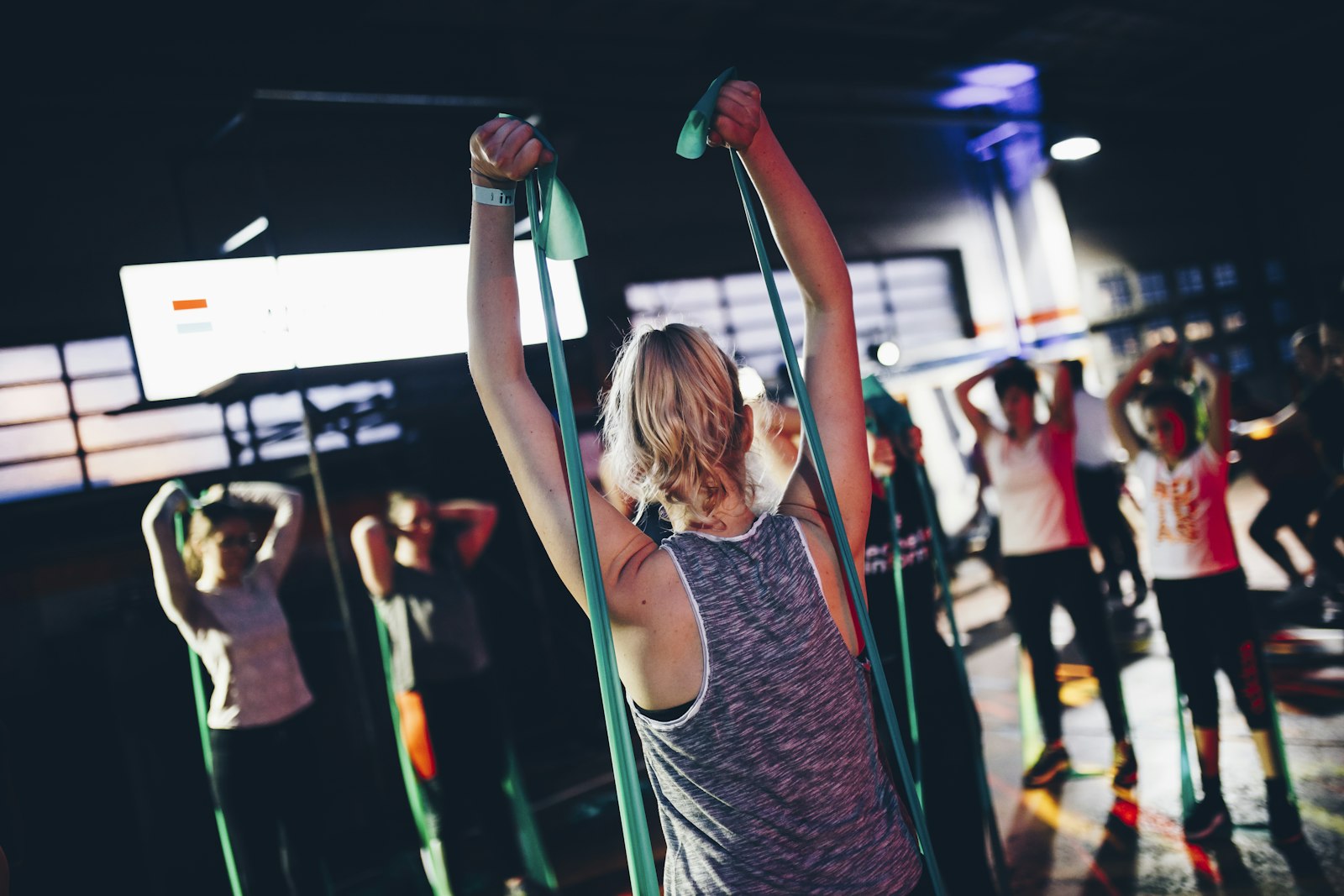 A group fitness class using resistance bands in a studio setting — the kind of subsidised group program many workplace wellness perks are built around.