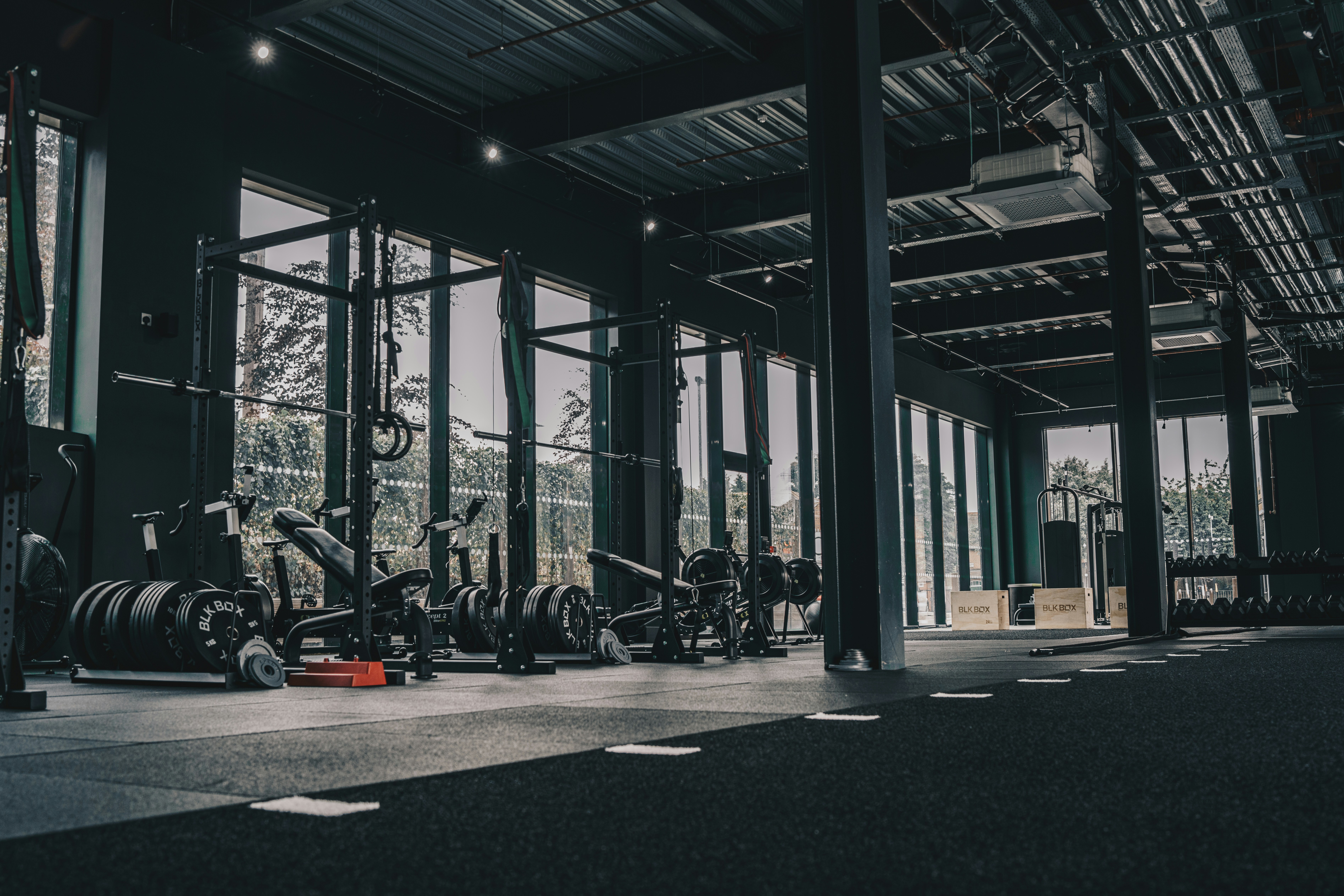 A barbell loaded with noticeably fewer plates than a working set, racked mid-session — the visual shorthand for a deload week, where the load drops but the bar stays in the program.