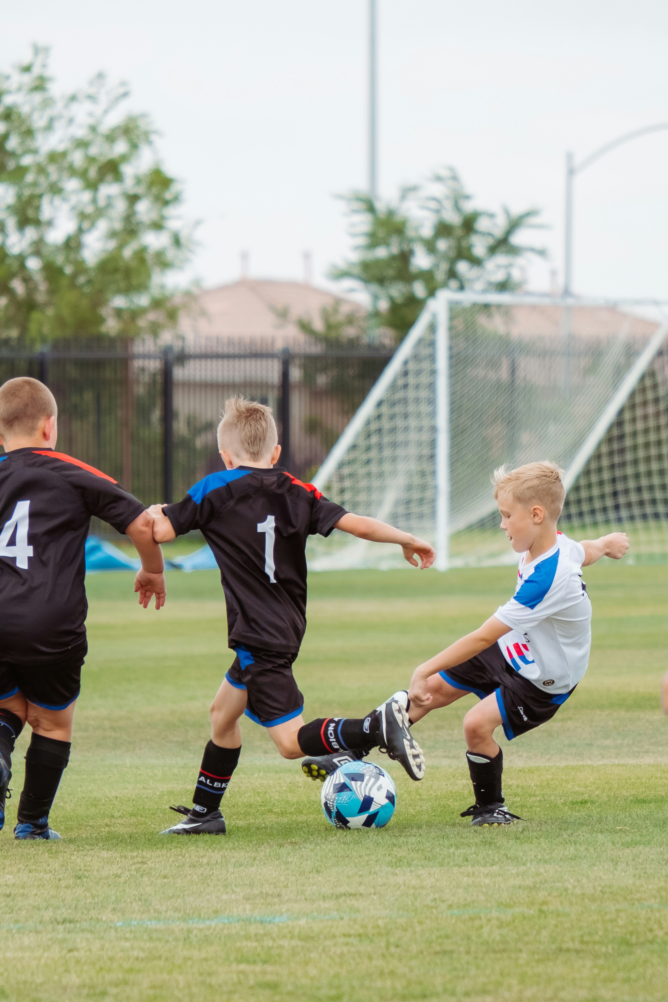 Young footballers playing a small-sided game on a training pitch — small-sided games are now FIFA's default teaching method for youth player development, not an occasional break from drilling.