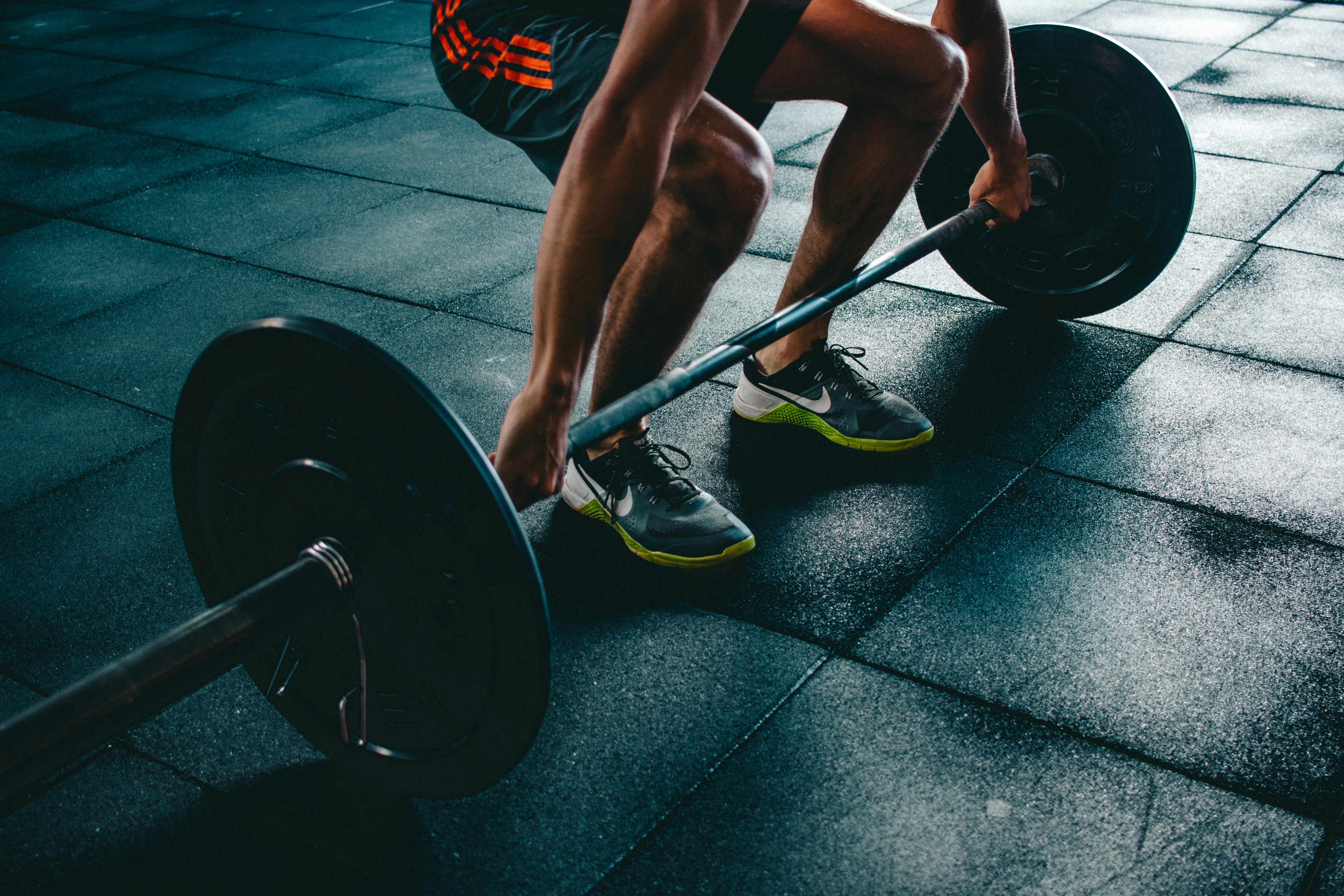 A youth team-sport athlete performing a loaded barbell squat in a gym — the kind of single, well-loaded in-season session the minimal-dose evidence says is enough to protect strength through a competitive season.