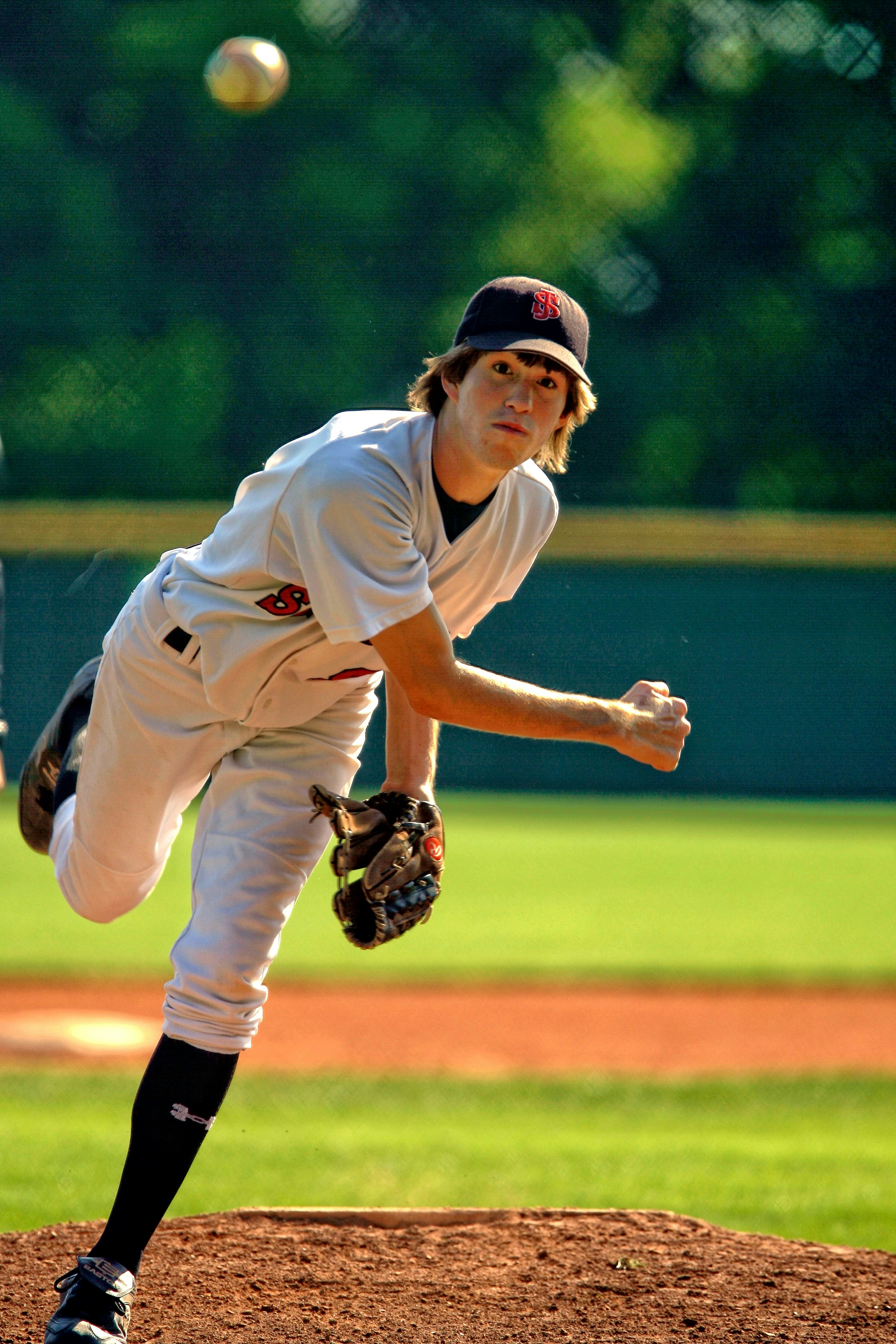 A young athlete icing an elbow on the sideline after a throwing session — the joint where epidemiological data shows the sharpest rise in youth overuse injury as single-sport specialization has increased.