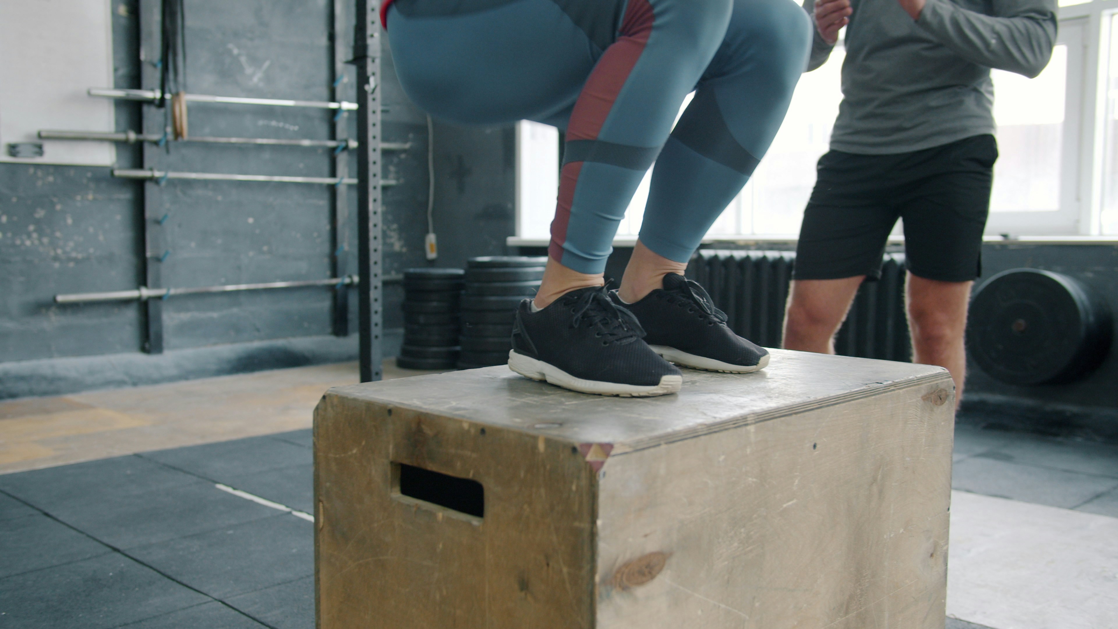 A young athlete performing a supervised box jump in a training facility — properly designed, progressively loaded plyometric training under qualified supervision is exactly what the safety evidence in this article describes, not the unsupervised depth jumps parents often picture.
