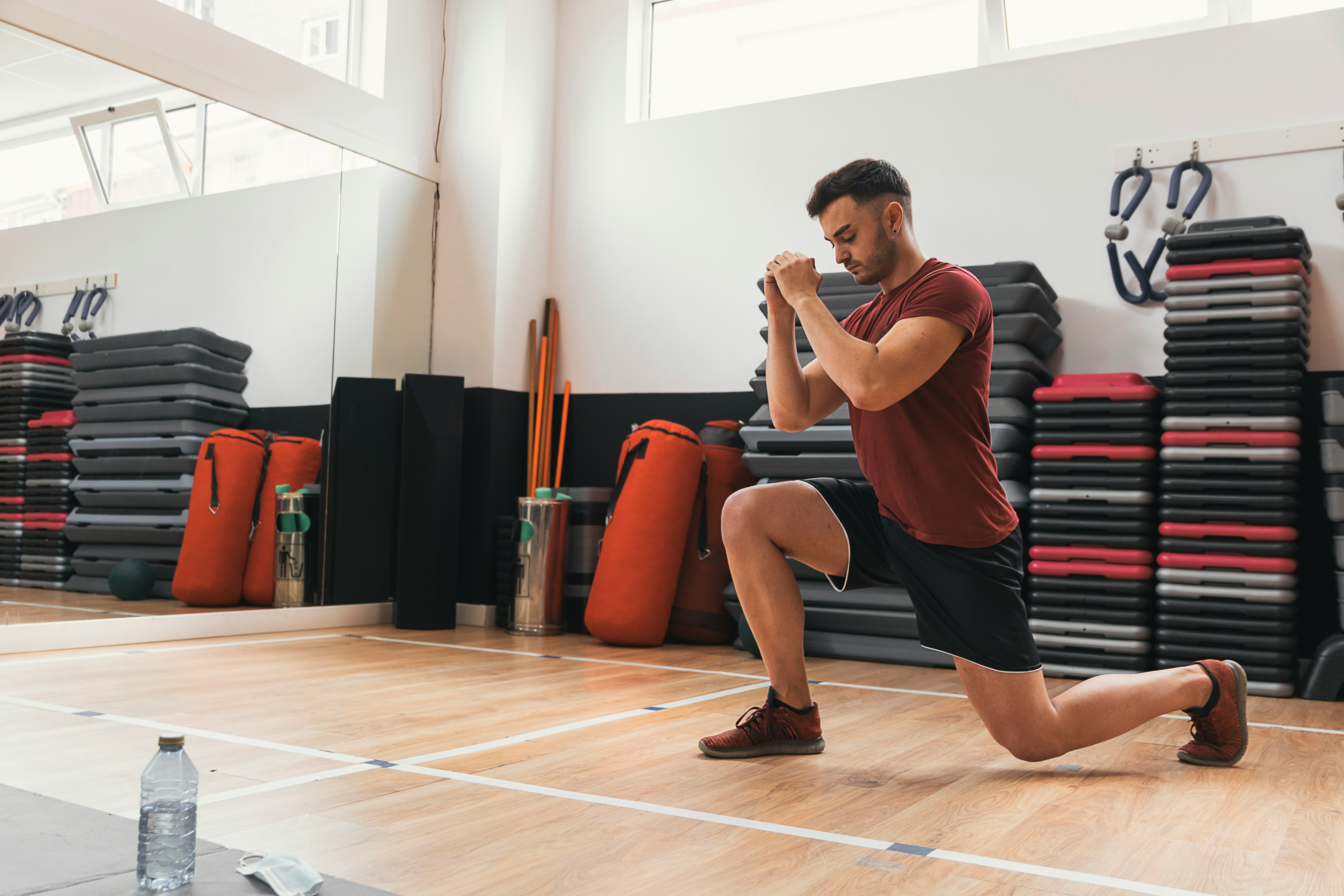 A team-sport athlete performing a heavy single-leg step-up in the gym — the exercise at the center of the research comparing unilateral and bilateral training for sport transfer.